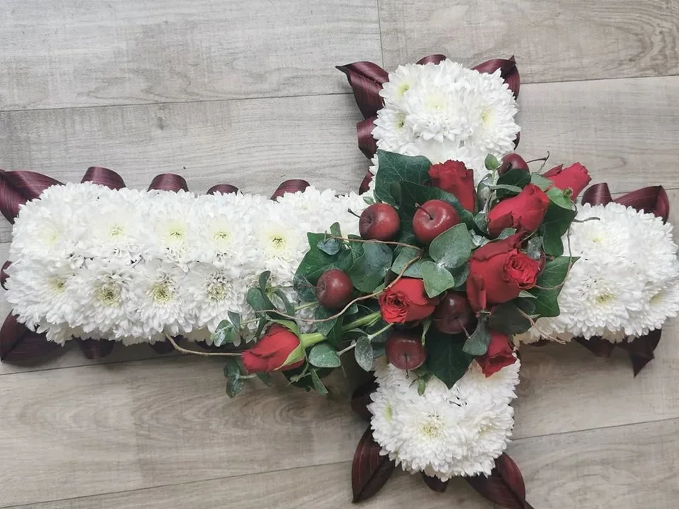 White floral cross with red rose detail